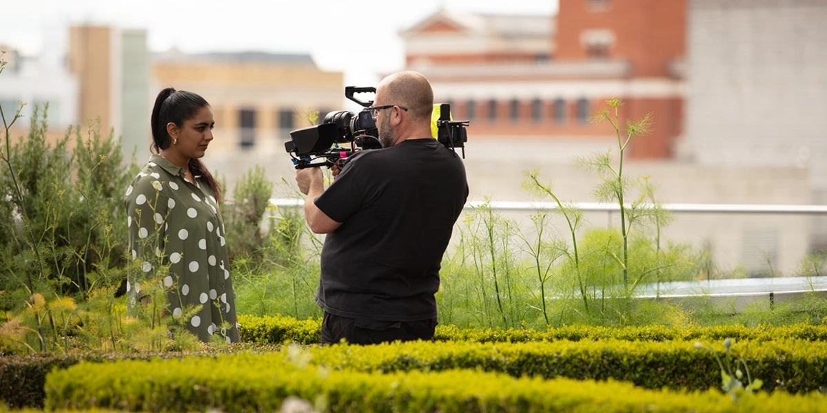 Poet Laureate Fatma Mohiuddin poetry performance being recorded by a camera