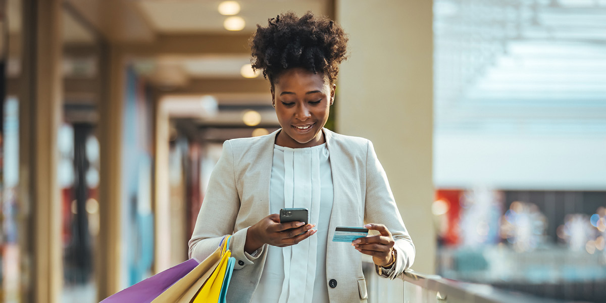 Lady with shopping bags making a purchase on mobile