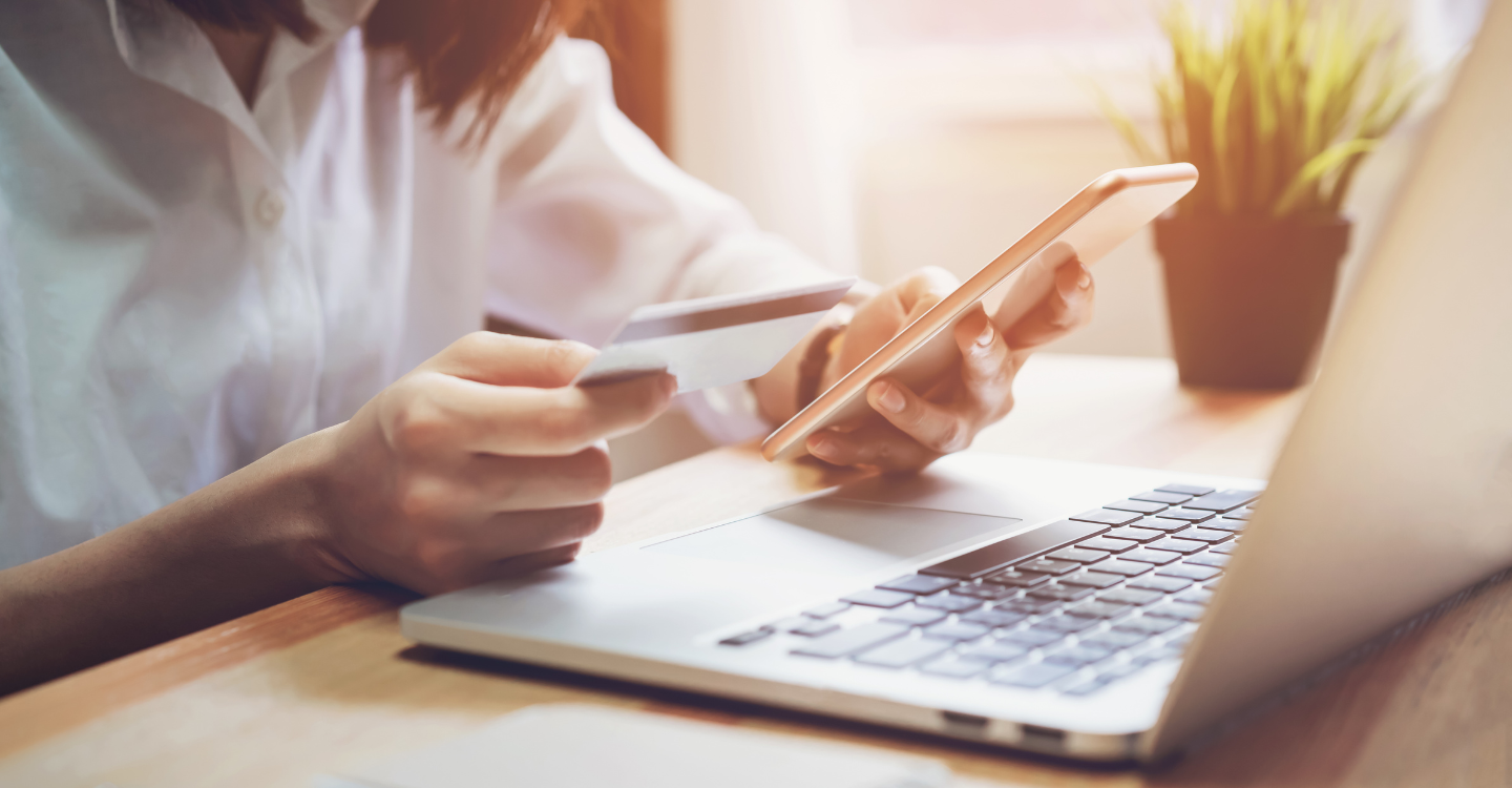 Woman holding credit card while shopping online and using a smartphone