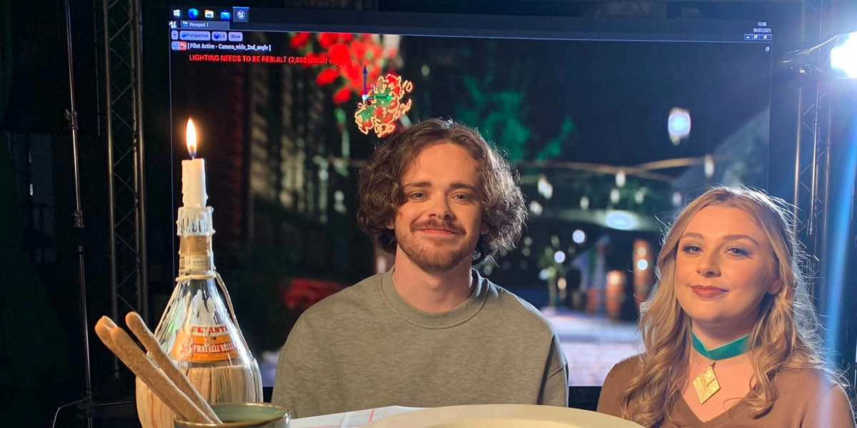 A couple sitting at a restaurant table on a film set