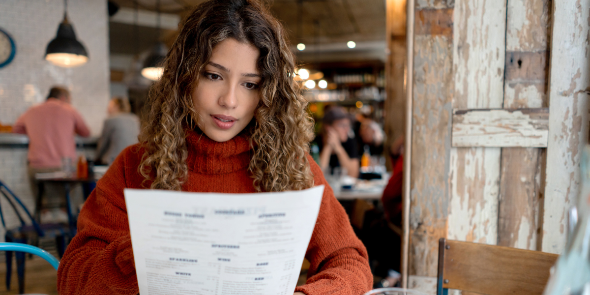 Woman reading a menu in restaurant