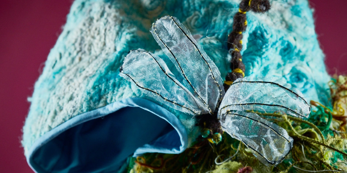 dragonfly made of of mesh sits on textile log