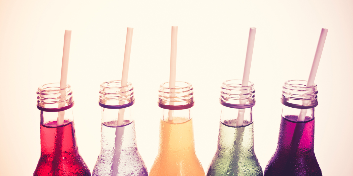 5 different colored drinks in a line with paper straws