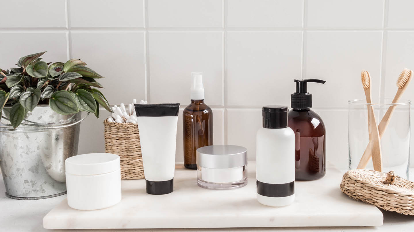 Cosmetic bottles standing on a marble slab in a bathroom