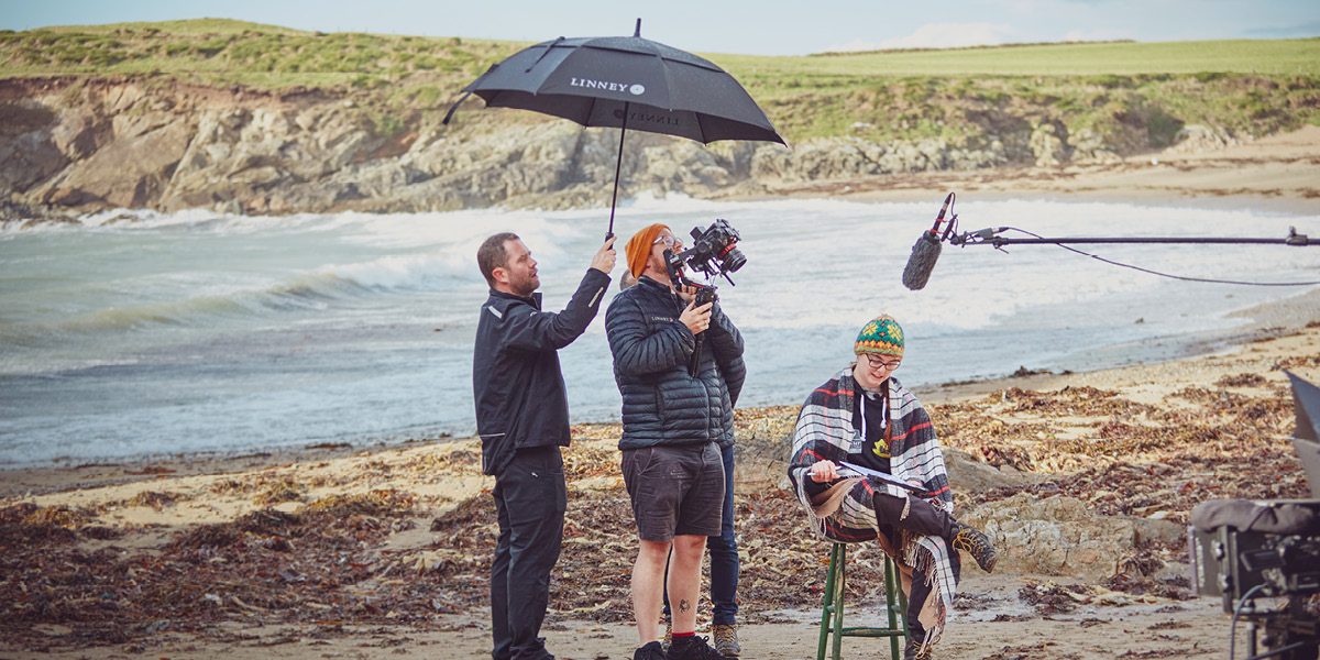 Camera crew filming documentary on the beach 