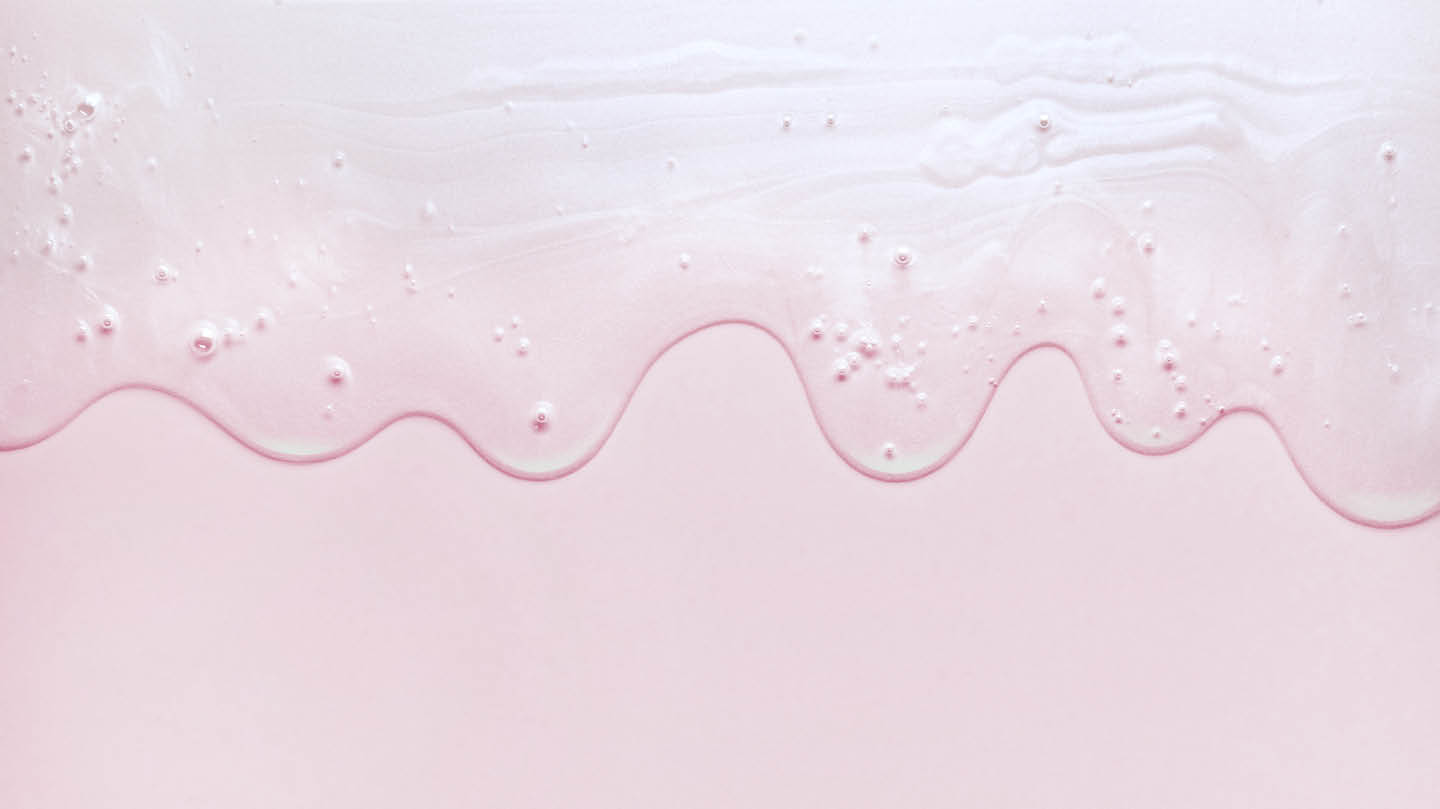 Skincare serum creating a wave at the top of the image against a pink background