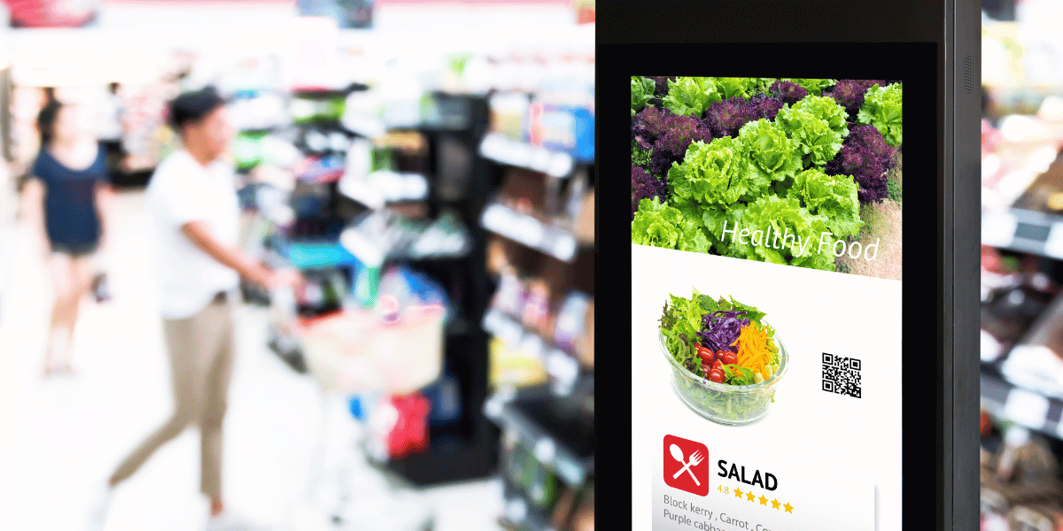 supermarket aisle with a digital screen showing salad products on