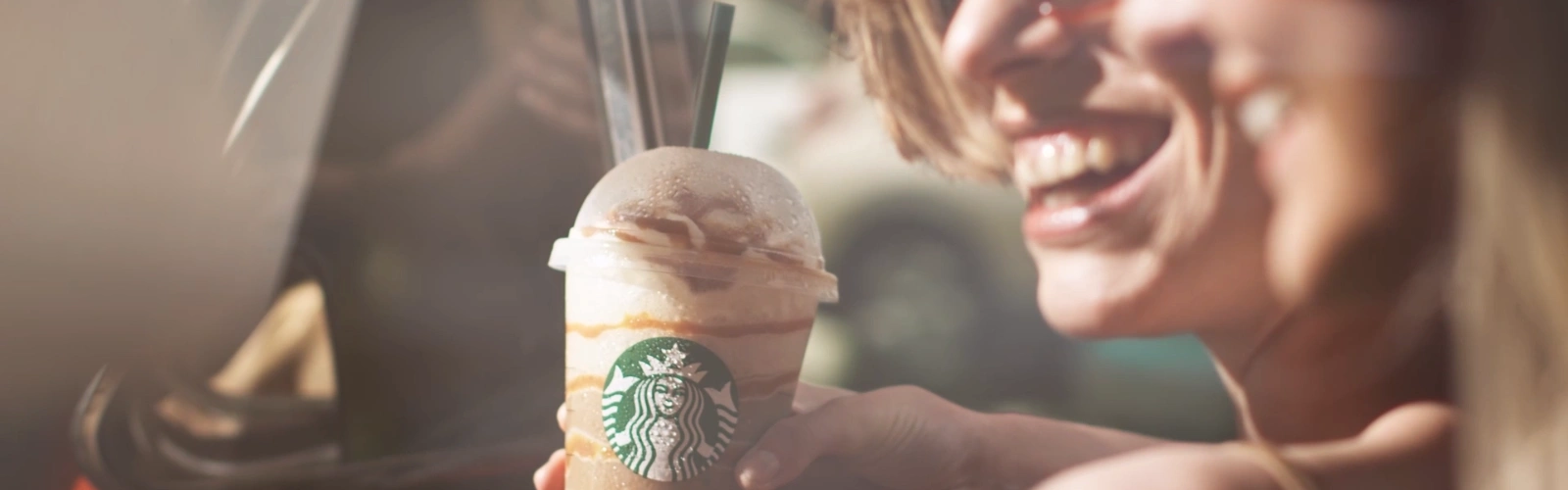 People laughing holding a Starbucks Frappe drink