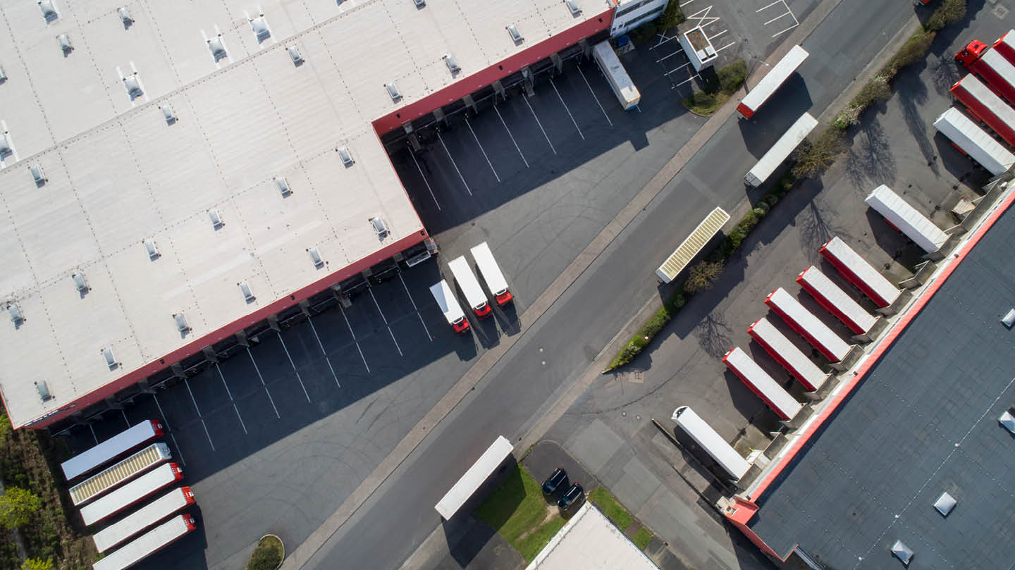 Aerial view of a warehouse with lorries entering and exiting the site