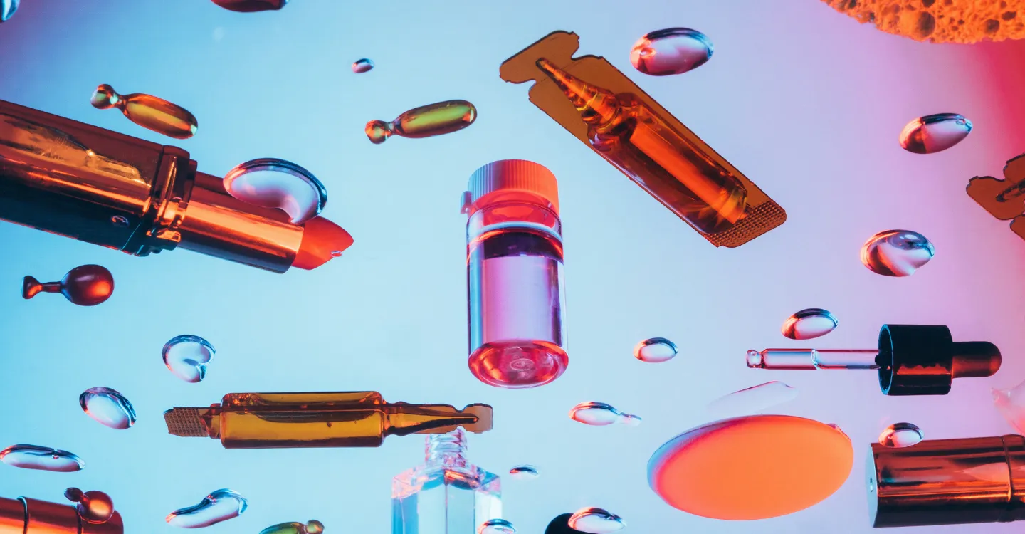 Blue background with bubbles of liquid floating around cosmetic products
