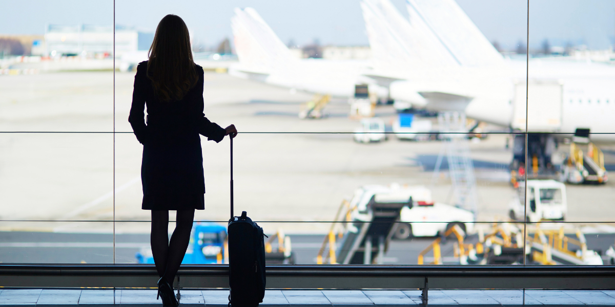 a woman in work attire waiting to board her plane