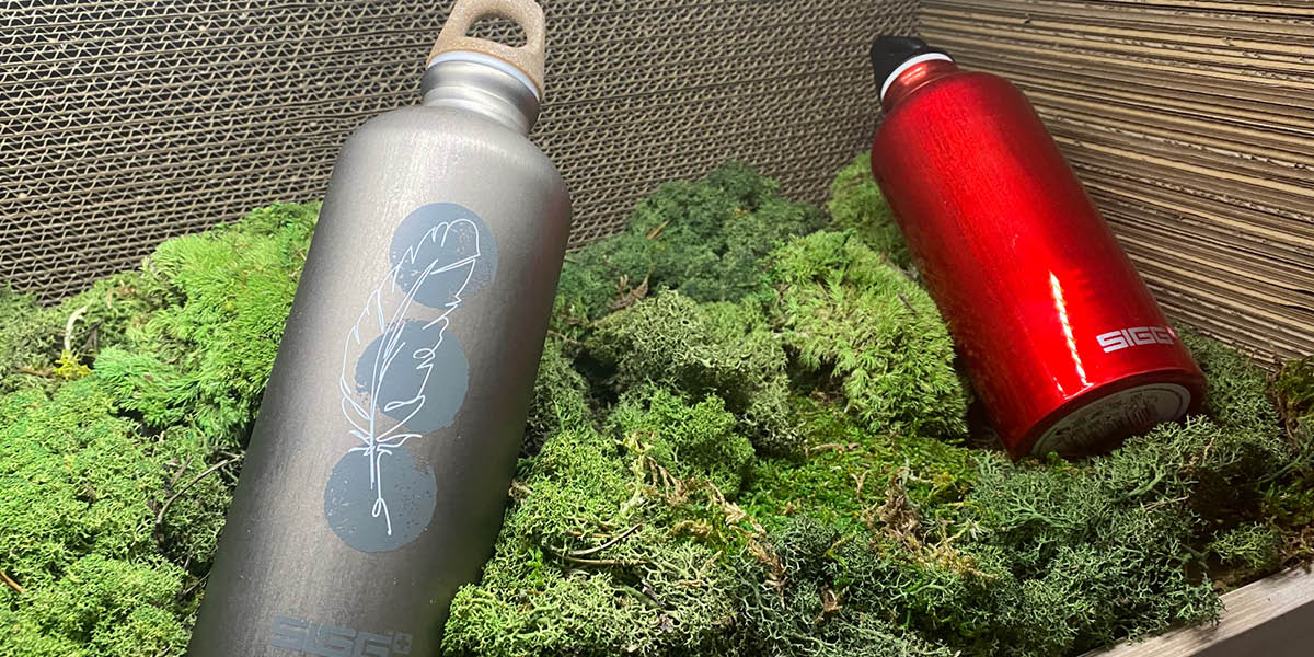 Water bottles sitting on green grass on a display shelf
