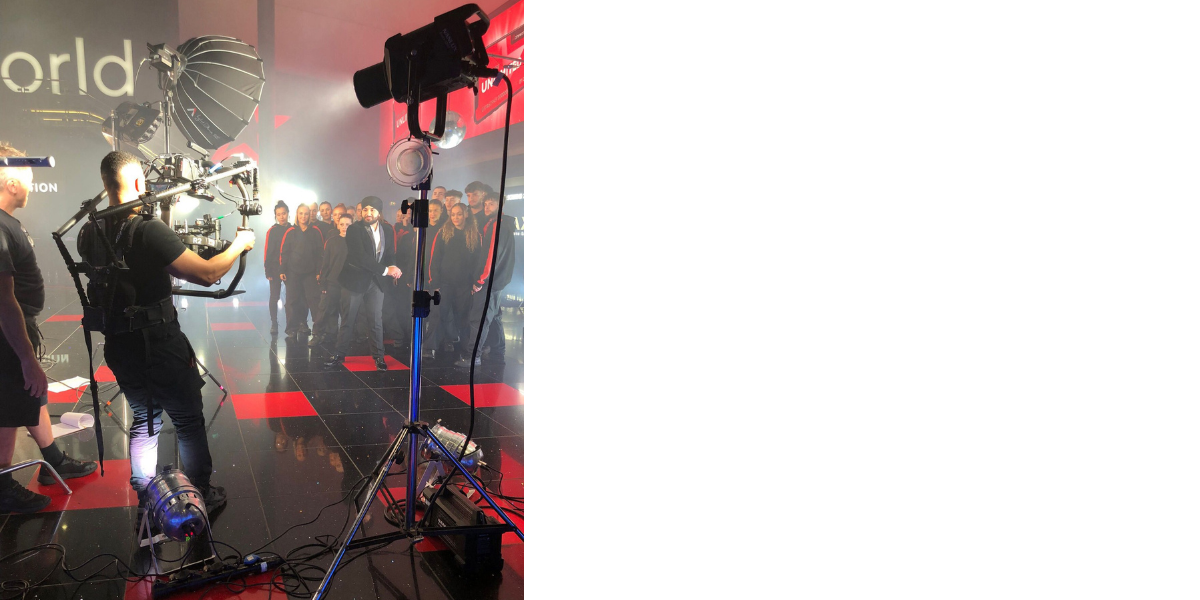 camera recording a presenter shake someone's hand in studio lights