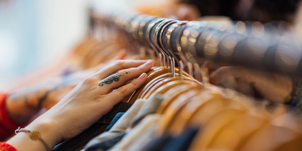 Person browsing clothes on a shopping rail