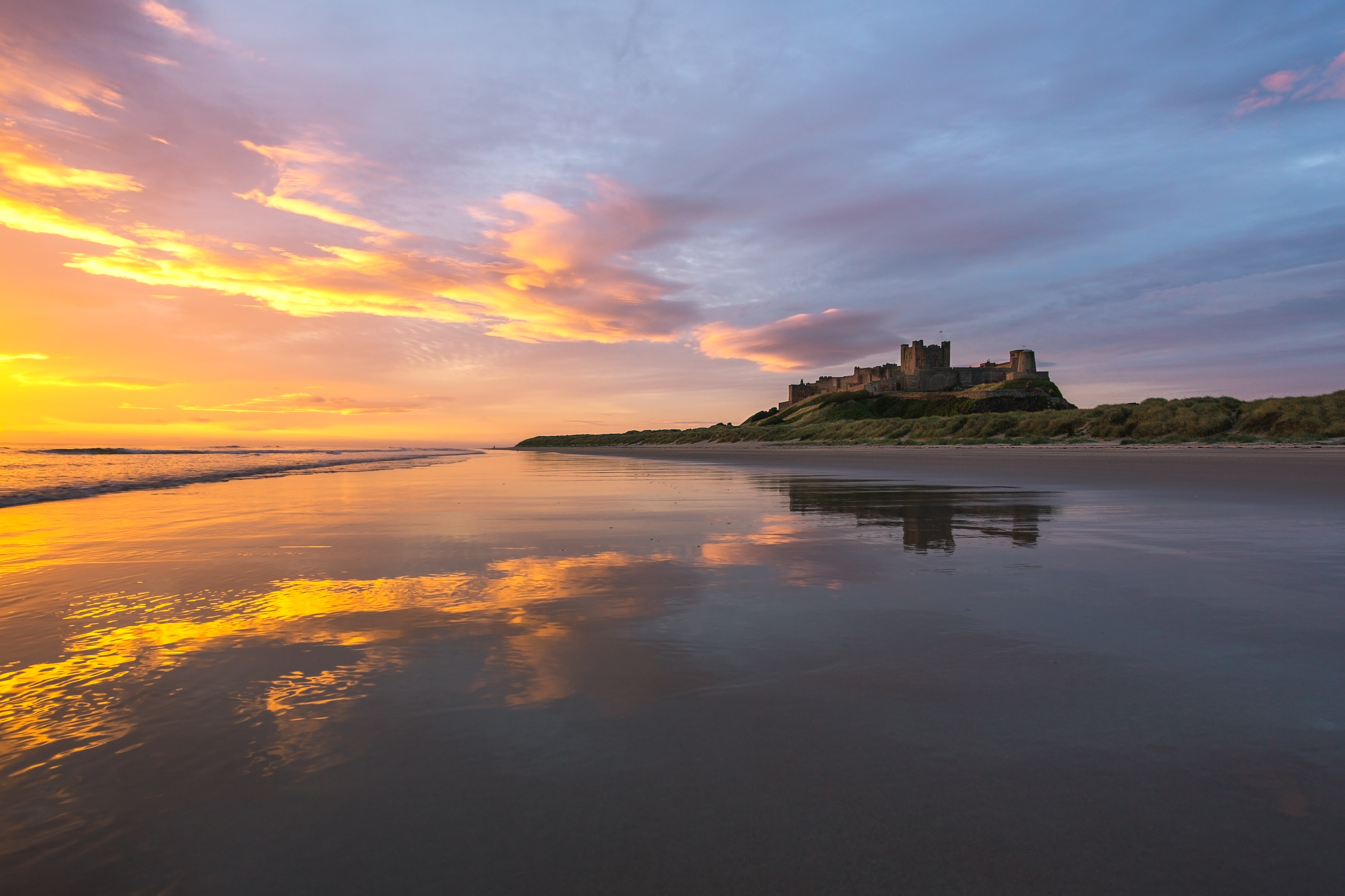 Bamburgh castle from the beach at sunset