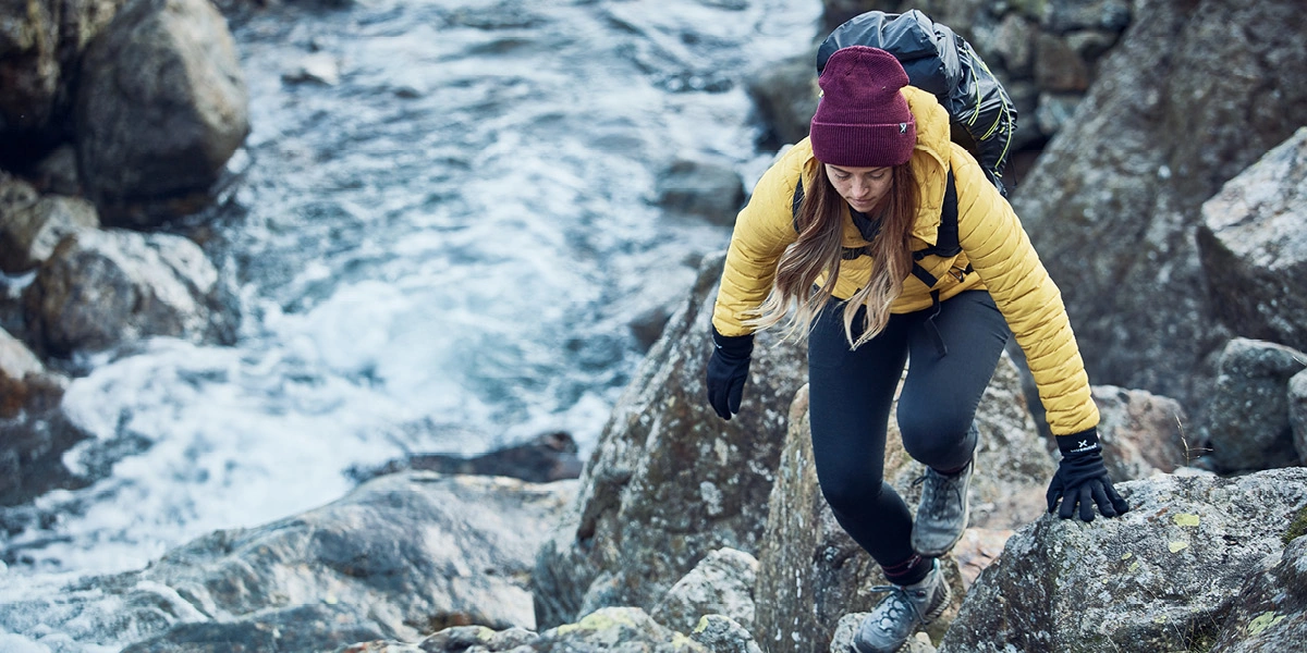 Lady climbing a mountain with a stream to the left