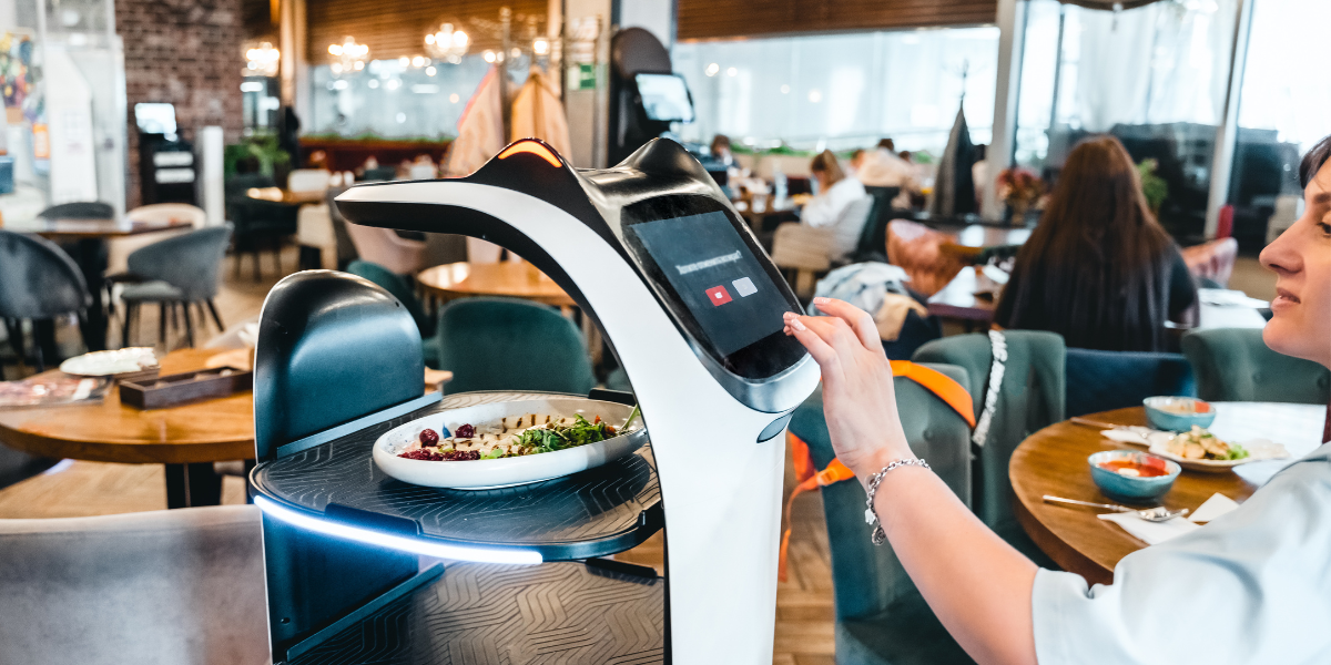 a robot delivering a customer some food at a restaurant