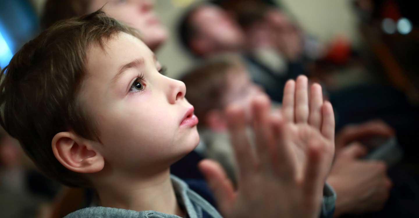 Child looking up clapping