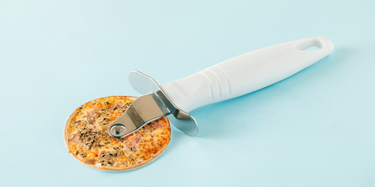 Pizza cutter with pizza on the wheel section 